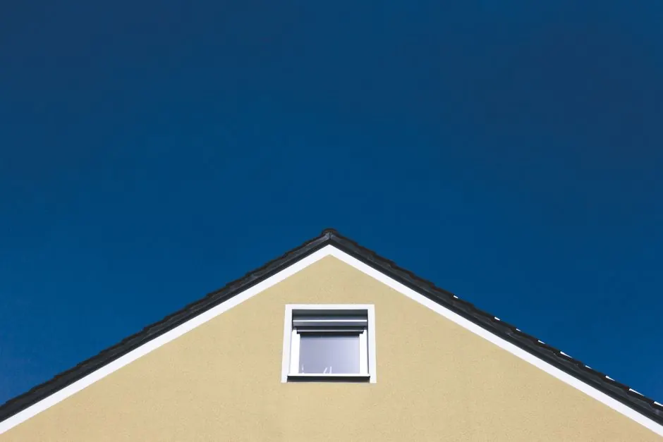 A modern house gable against a clear blue sky, highlighting minimalistic architectural design.